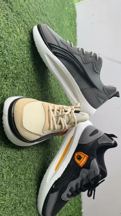 Men's chunky mesh sneakers in grey, beige, and black — wholesale display
